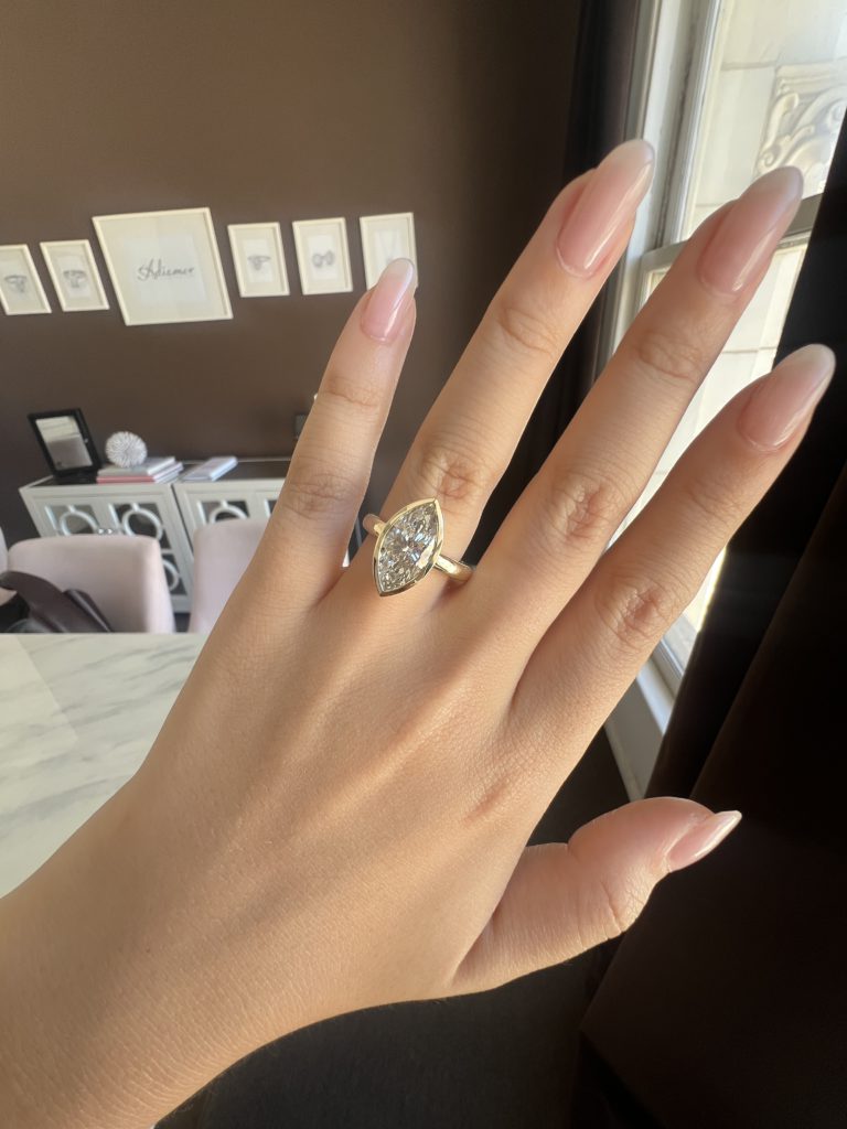 Thick bezel Setting on ring finger with a marquise diamond 