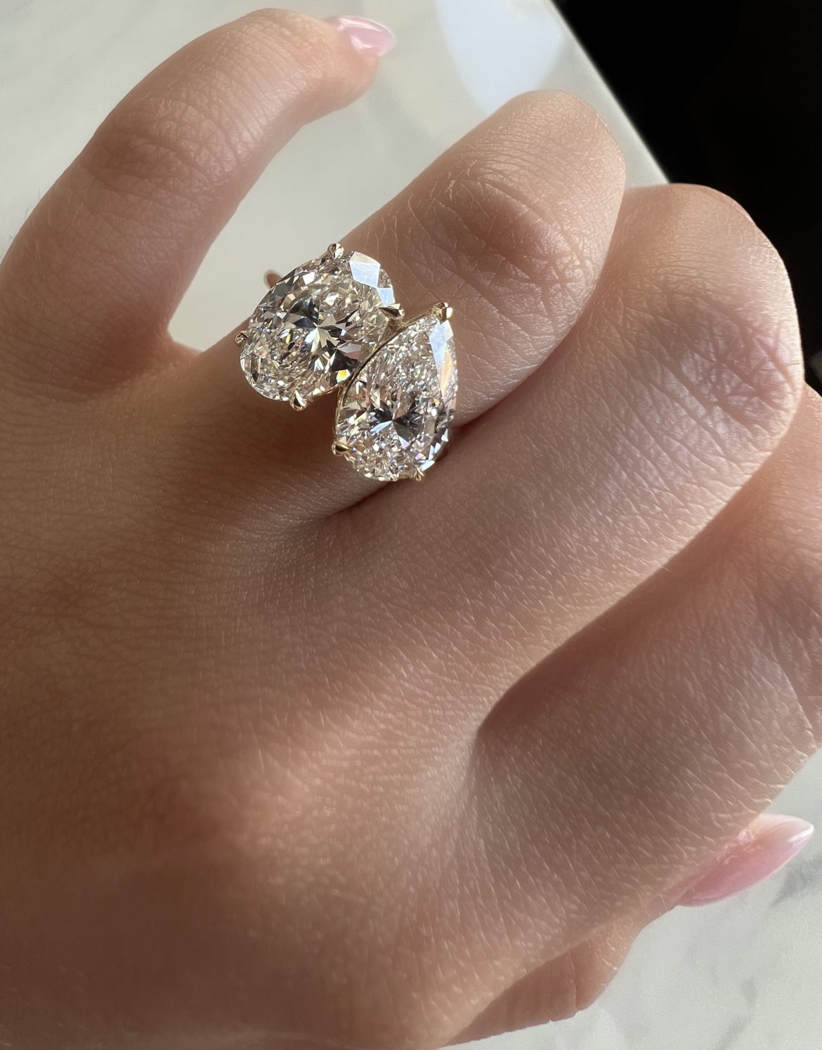 Pear and oval 2-stone engagement ring on the hand