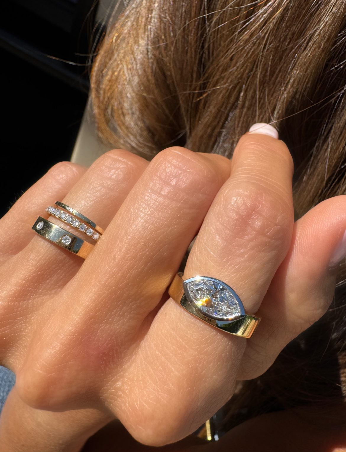 An east west thick bezel setting featured on the index finger